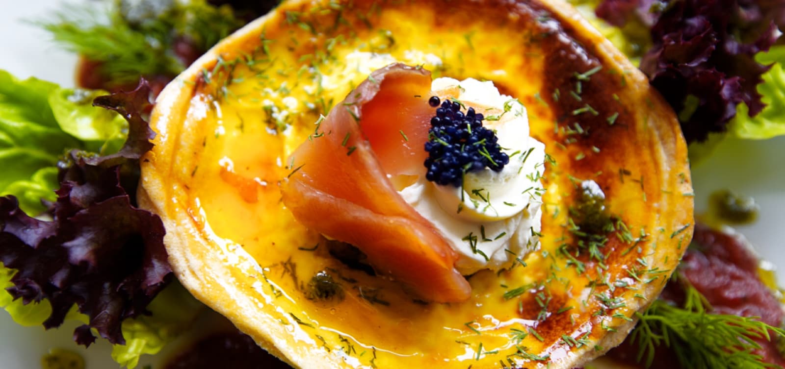 Gourmet savoury tart topped with smoked salmon, dill and fresh salad